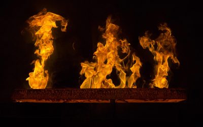 A closeup shot of a red hot iron with flames and black background